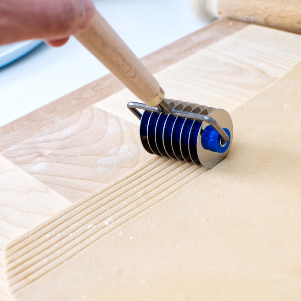 Tagliatelle roller cutter being used on pasta